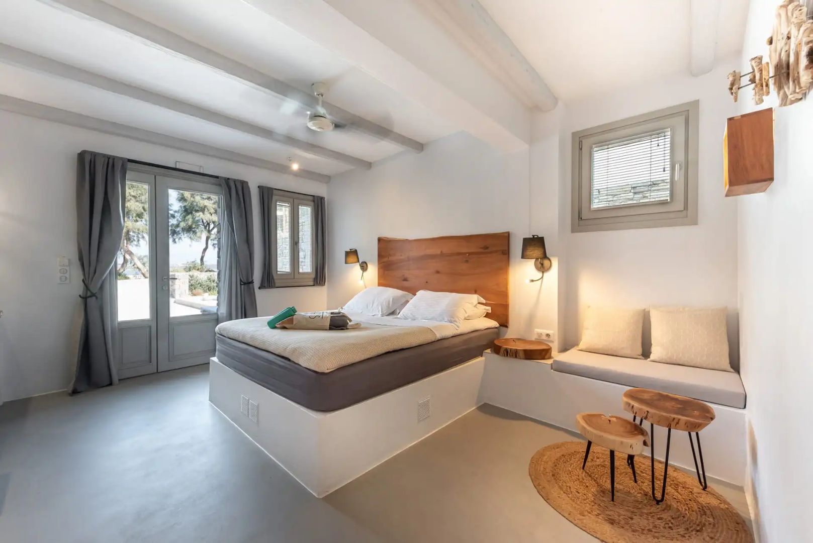 Schlafbereich mit Doppelbett, Sitzgelegenheit und Ausgang zur Terrasse.