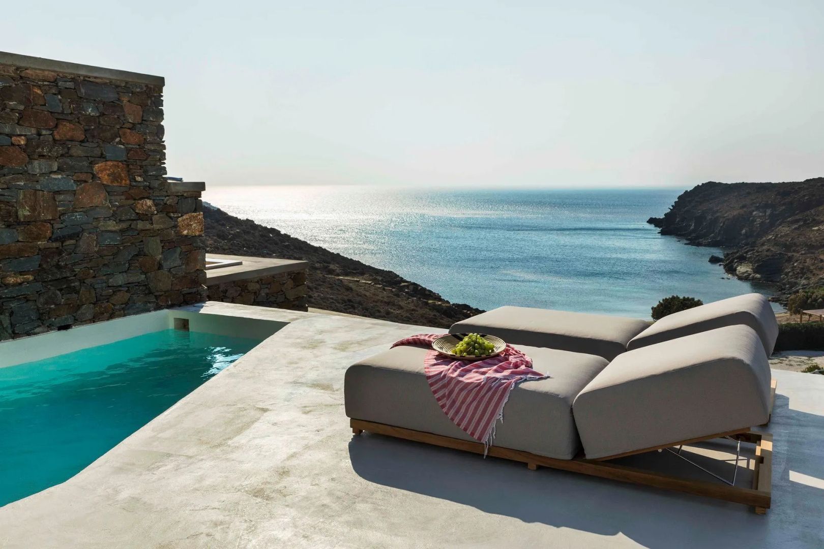 Sonnenterrasse mit Liegepolster und kleinem Pool mit freiem Blick auf das Meer.