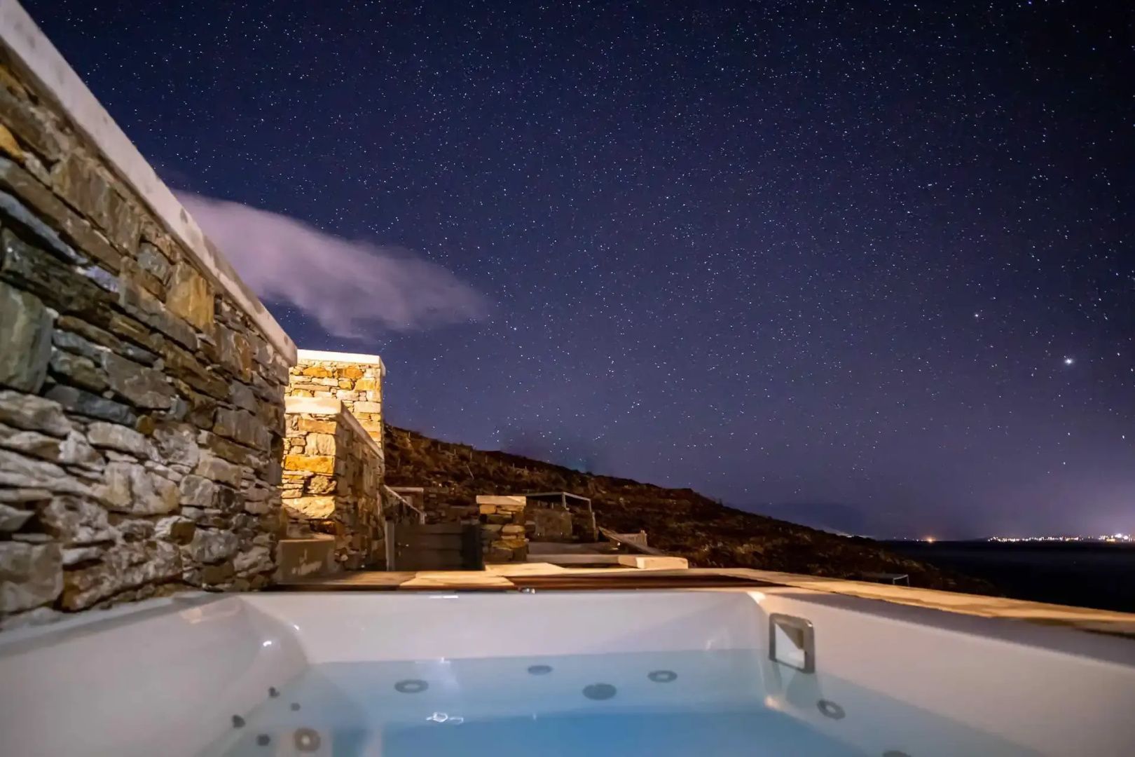 Beleuchteter Whirlpool im Außenbereich auf der Terrasse bei Nacht.
