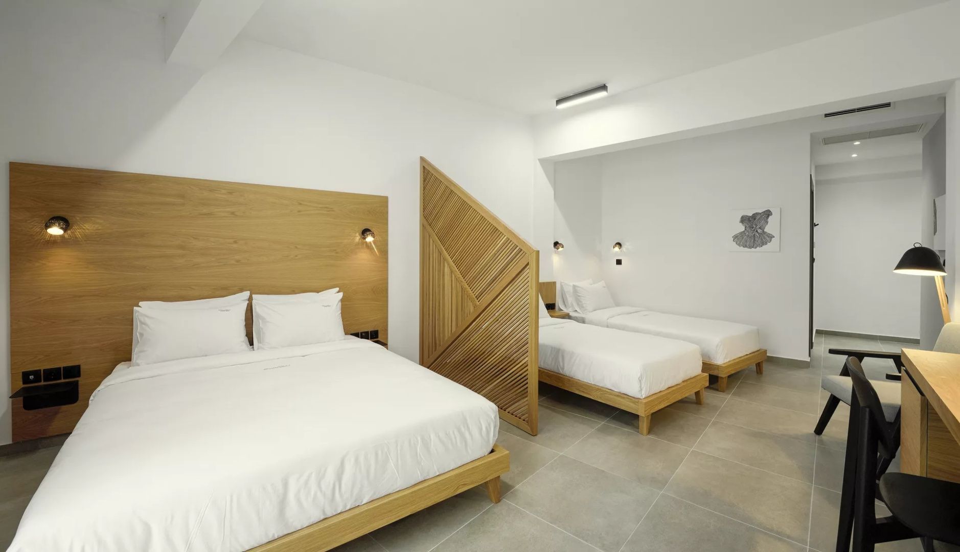 Geräumiges Zimmer mit einem Doppelbett, zwei Einzelbetten und Holztrennwand.