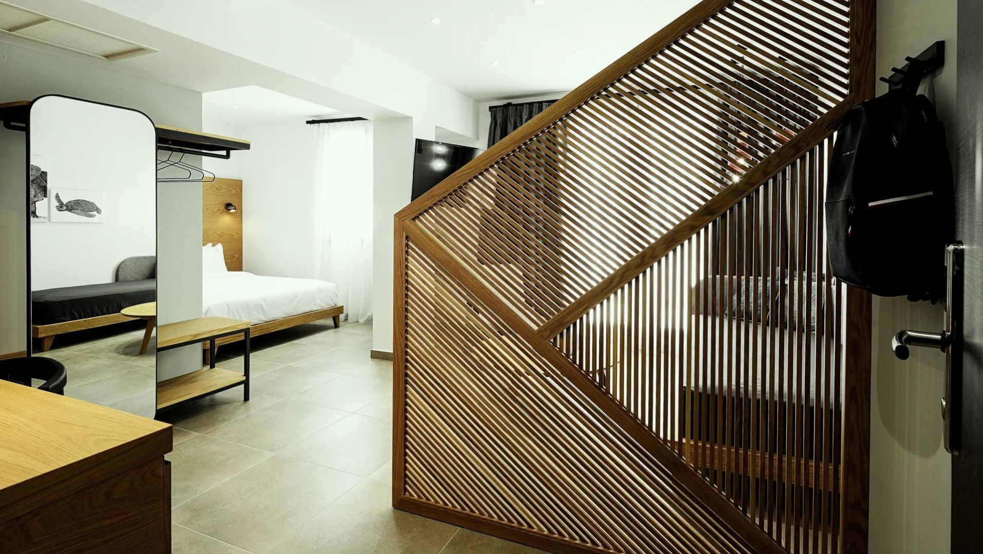 Holzverkleideter Raumteiler im modern gestalteten Hotelzimmer.