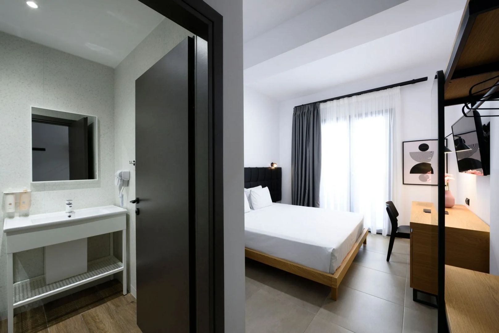 Blick durch den Flur auf das angrenzende Badezimmer und das hell erleuchtete Schlafzimmer.