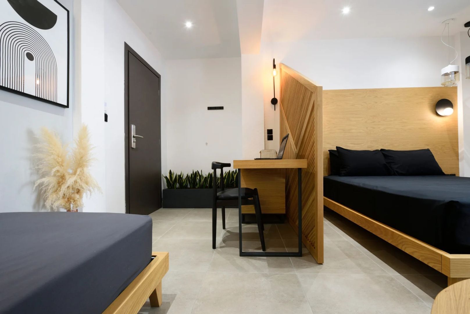Arbeitsbereich im Zimmer mit Holzschreibtisch, Stuhl und einer Holz-Trennwand.