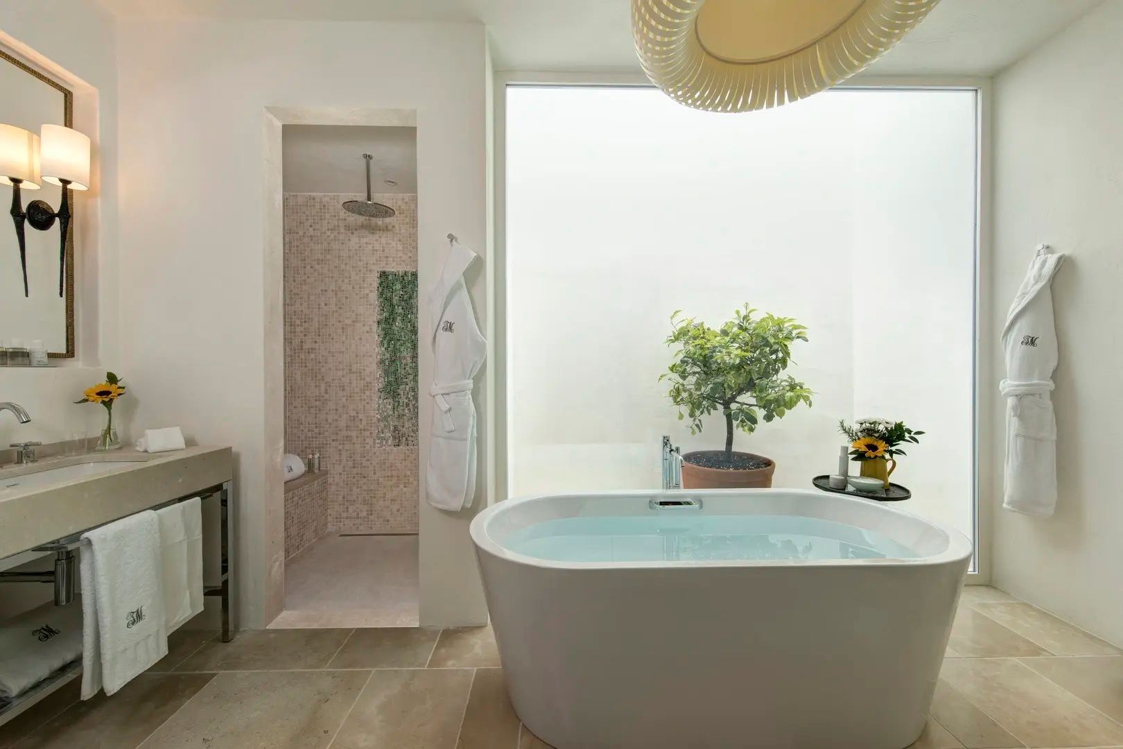 Modernes Badezimmer mit freistehender Badewanne, Pflanze und Duschbereich.