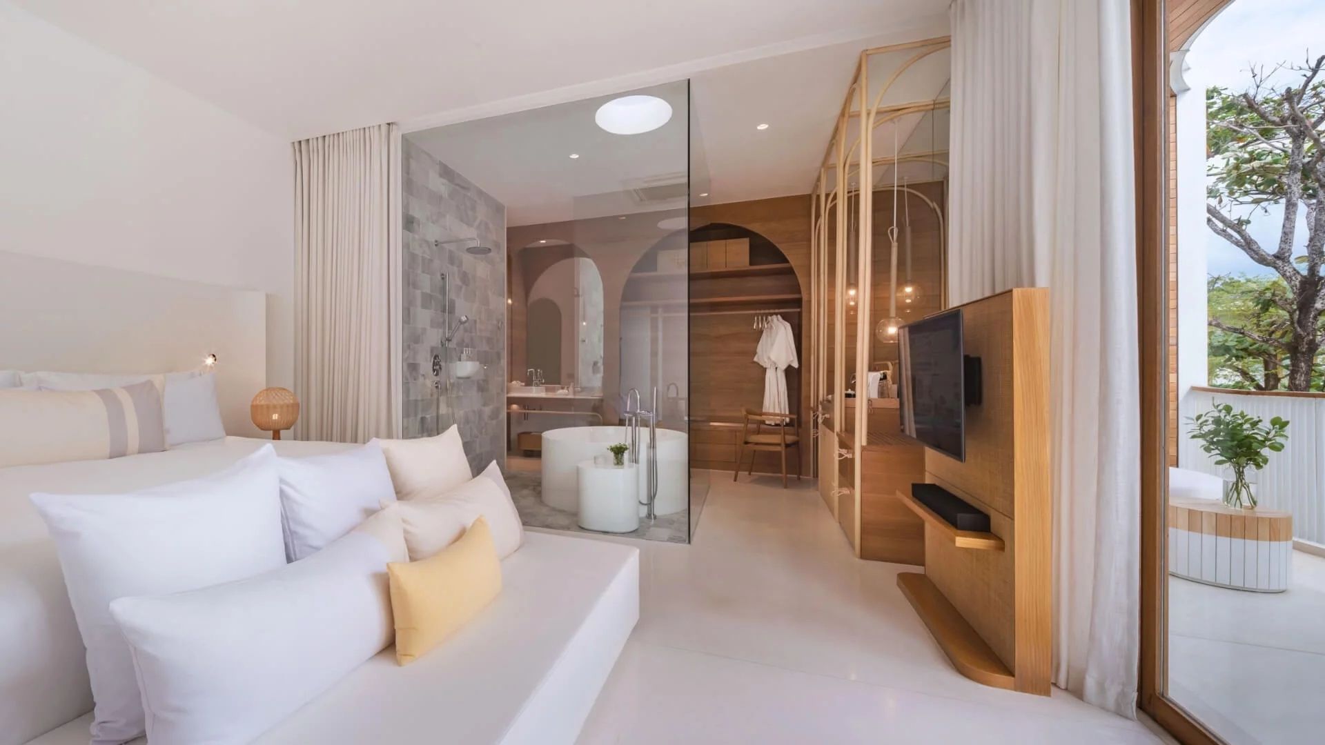 Sitzbereich im Hotelzimmer mit Holzelementen und Blick auf das Badezimmer.