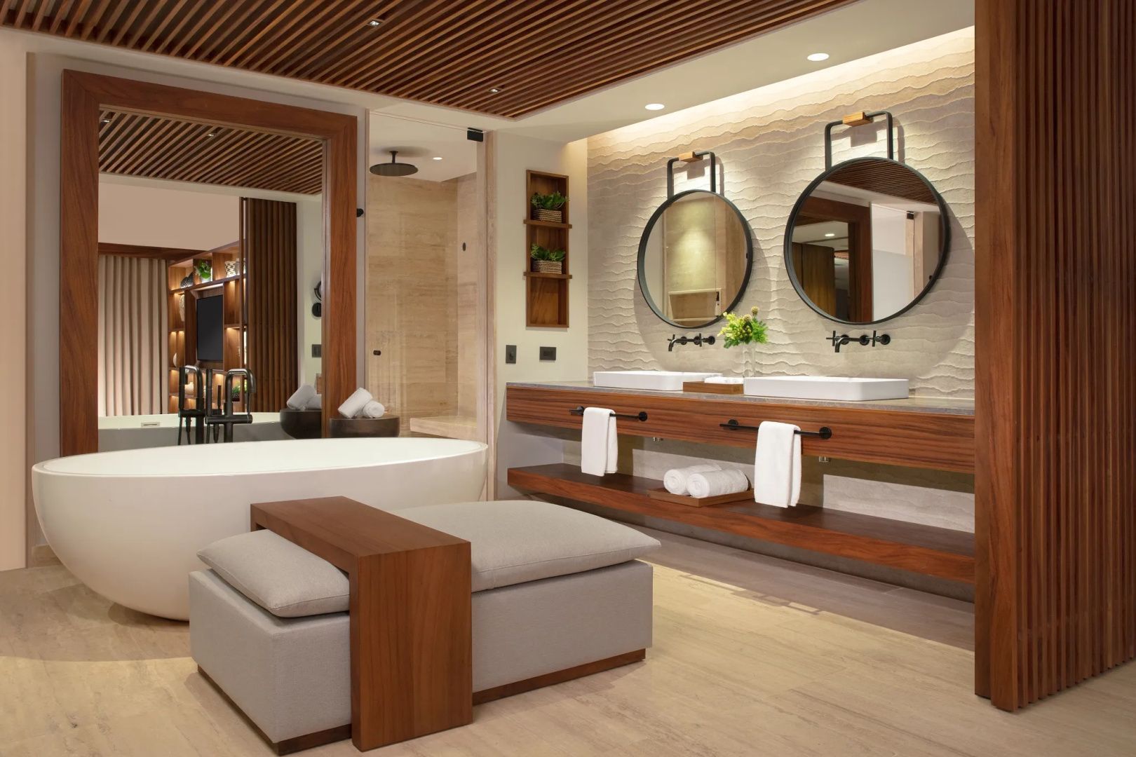 Badezimmer mit zwei Waschbecken, runden Spiegeln, freistehender Badewanne und Dusche.