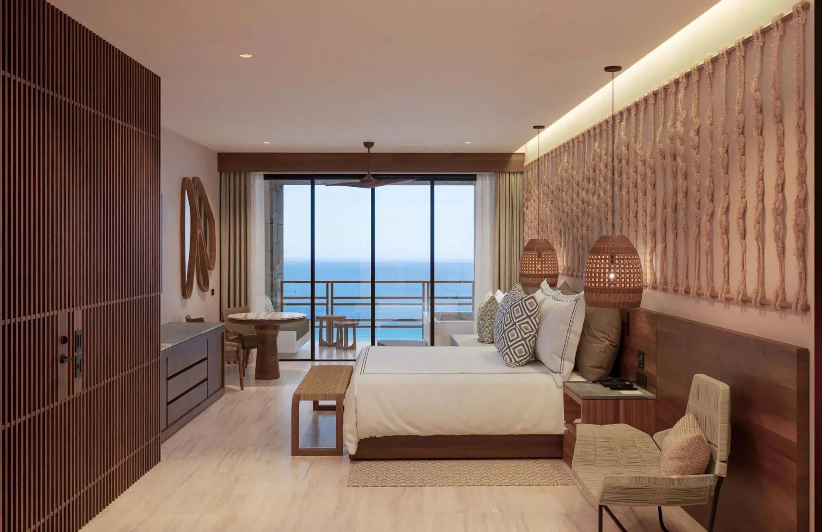 Helles Schlafzimmer im Hotel mit Blick durch die Glasfront auf den Balkon und das Meer.
