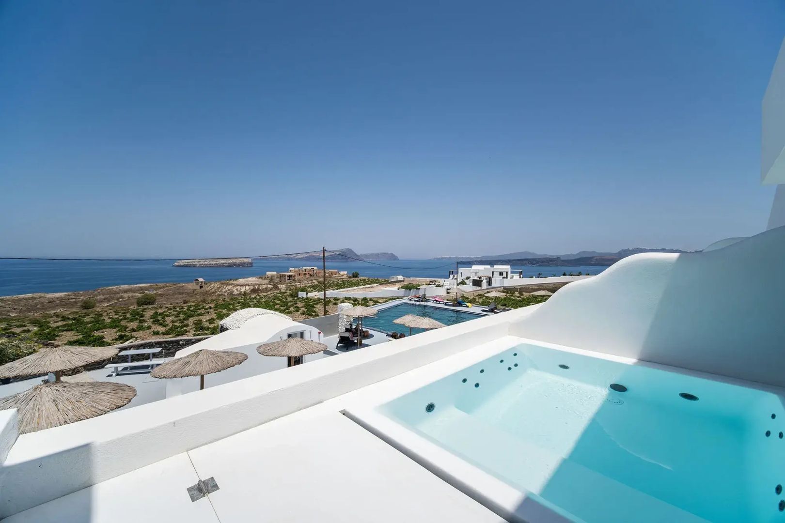 Blick von einer Terrasse mit Whirlpool auf die Küste und das Meer.