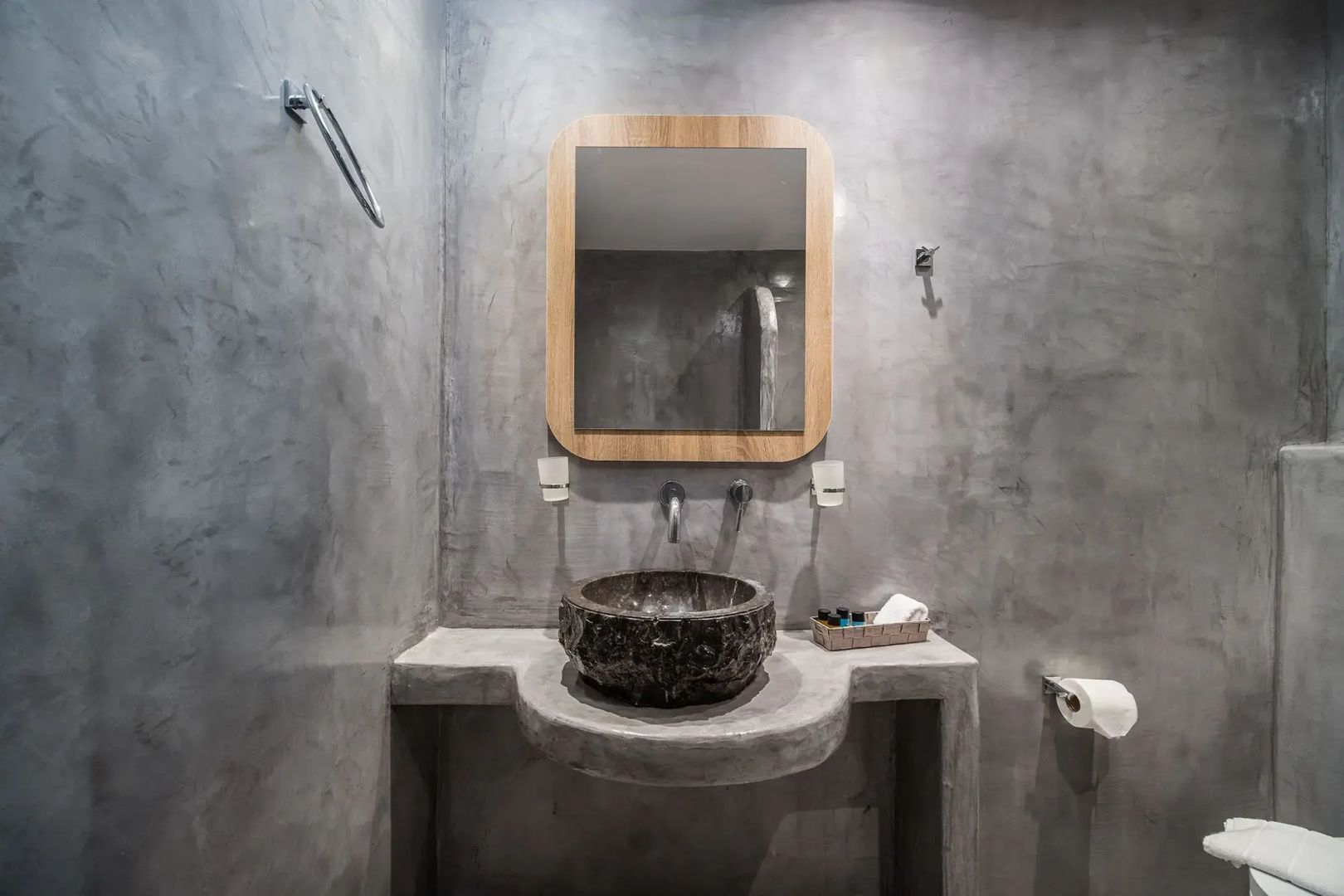 Badezimmer in Grau mit Waschbecken aus Stein und rechteckigem Spiegel.