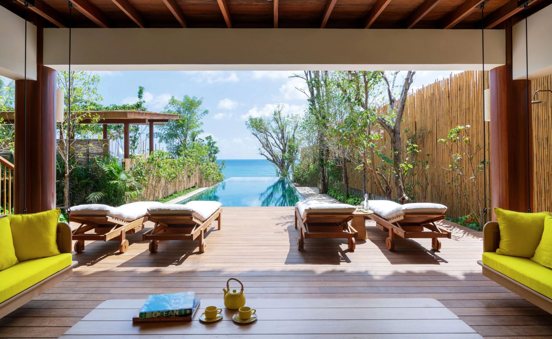 Sonnendeck aus Holz mit Liegen und ein kleiner Infinitypool mit Blick auf das Meer.
