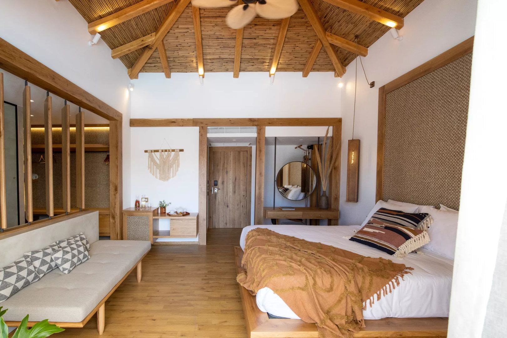 Schlafbereich mit Doppelbett, Holzfußboden und Sicht auf den Eingangsbereich.