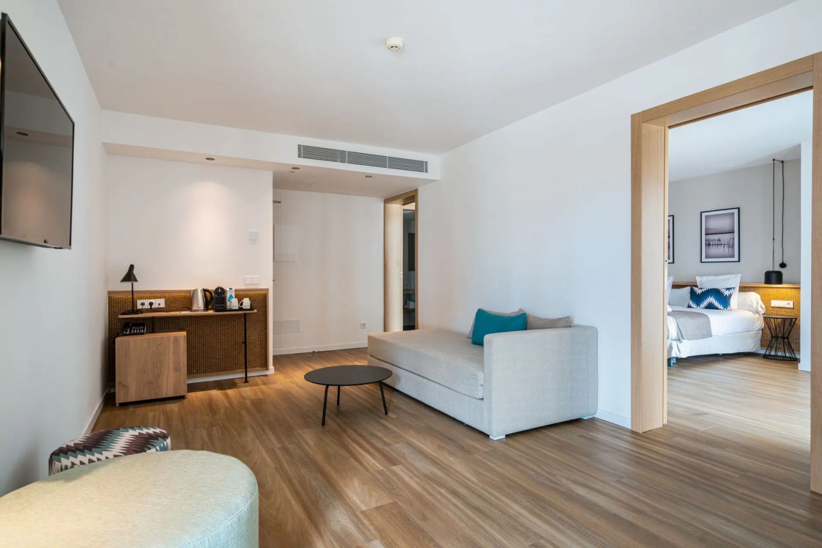 Geräumiger Wohnbereich einer Suite mit Sofa, Couchtisch und Vorrichtung für Kaffee und Tee.