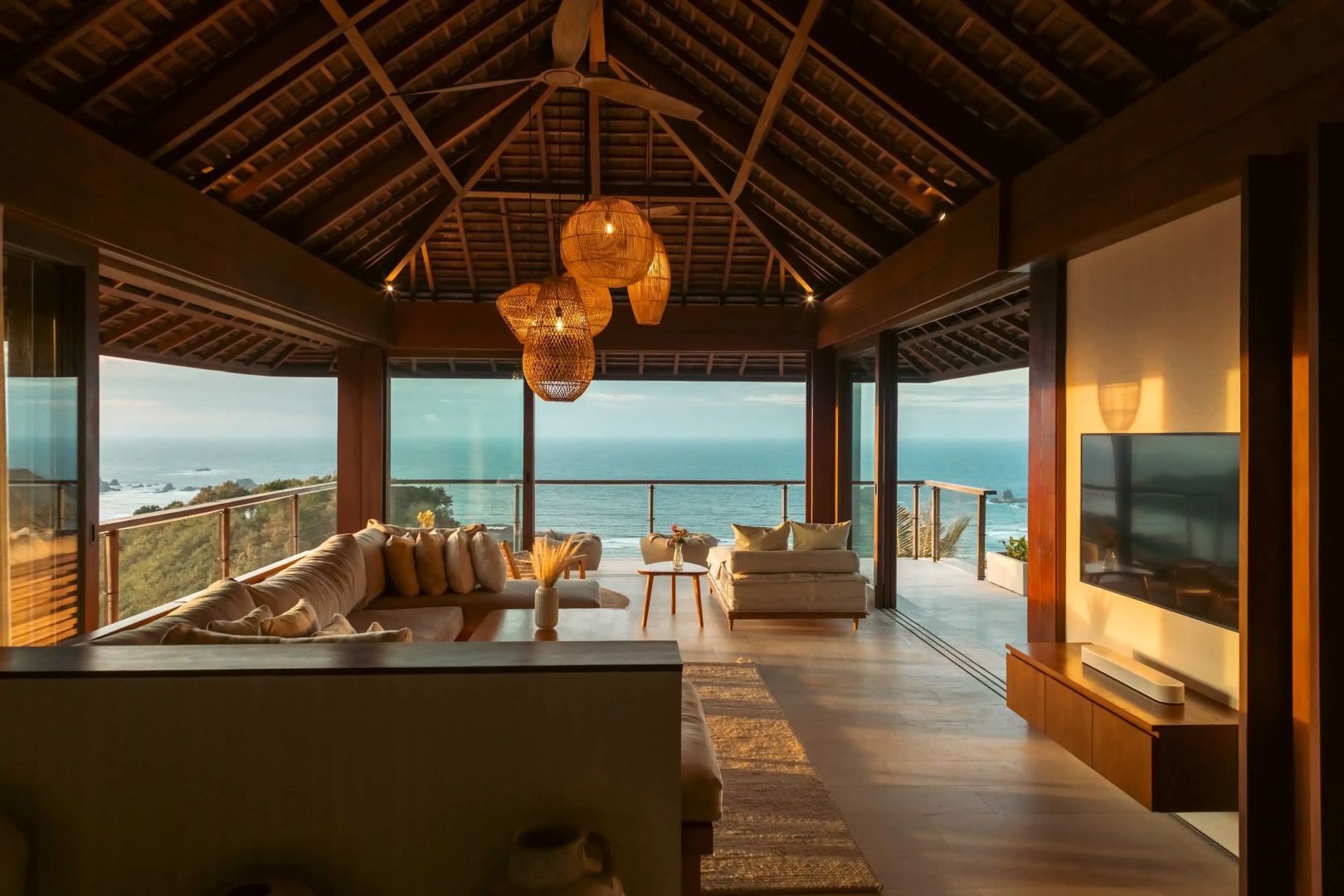 Offener Wohnbereich mit Holzdecke und Panoramablick auf das Meer.