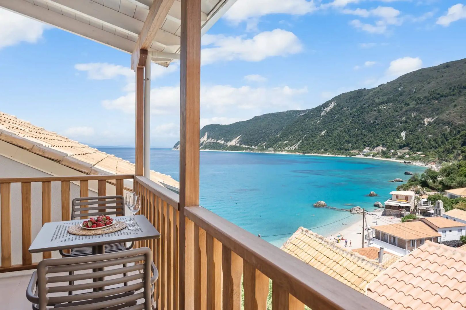Überdachter Holz-Balkon mit weitem Panoramablick auf den Strand, Küstenfelsen und das Meer.