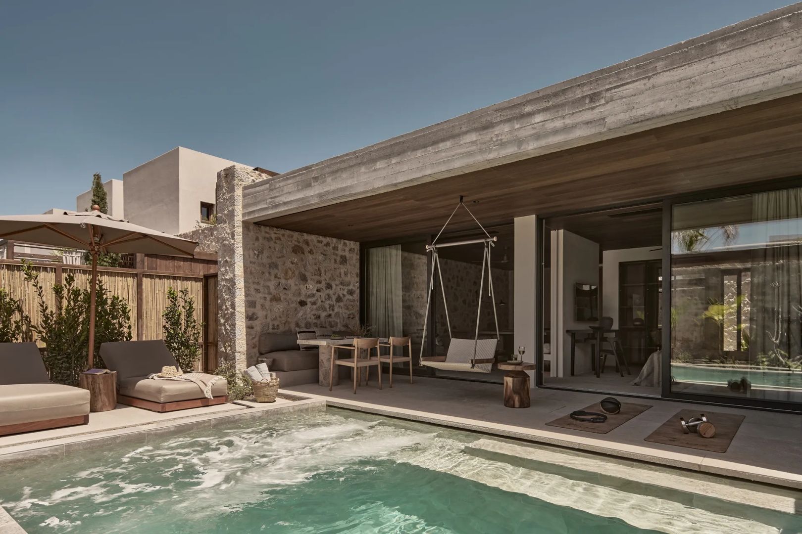Außenbereich einer Suite mit Steinfassade, Terrasse und privatem Pool.