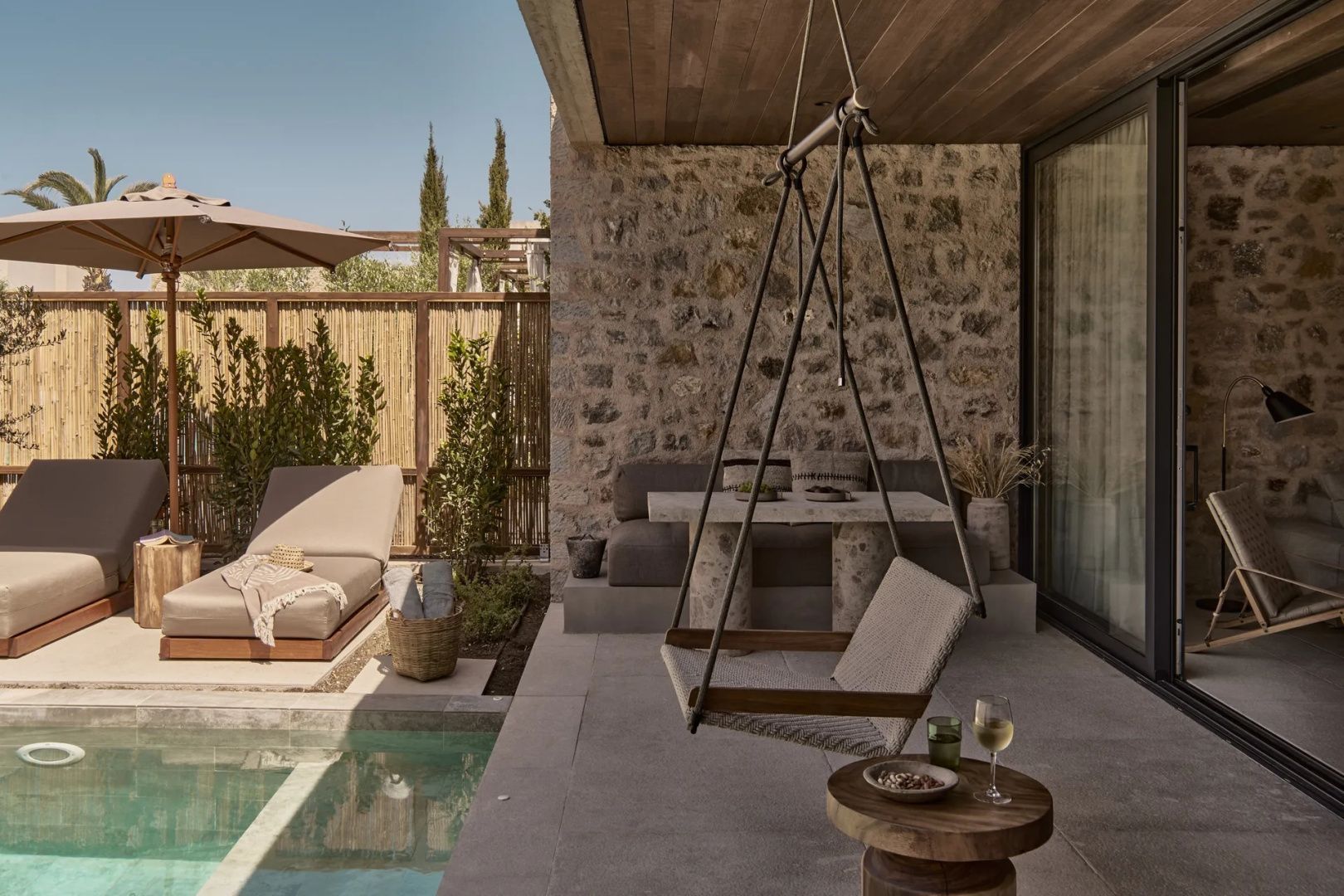 Überdachte Terrasse mit Hängesessel, Sitzecke und eigenem Poolzugang.