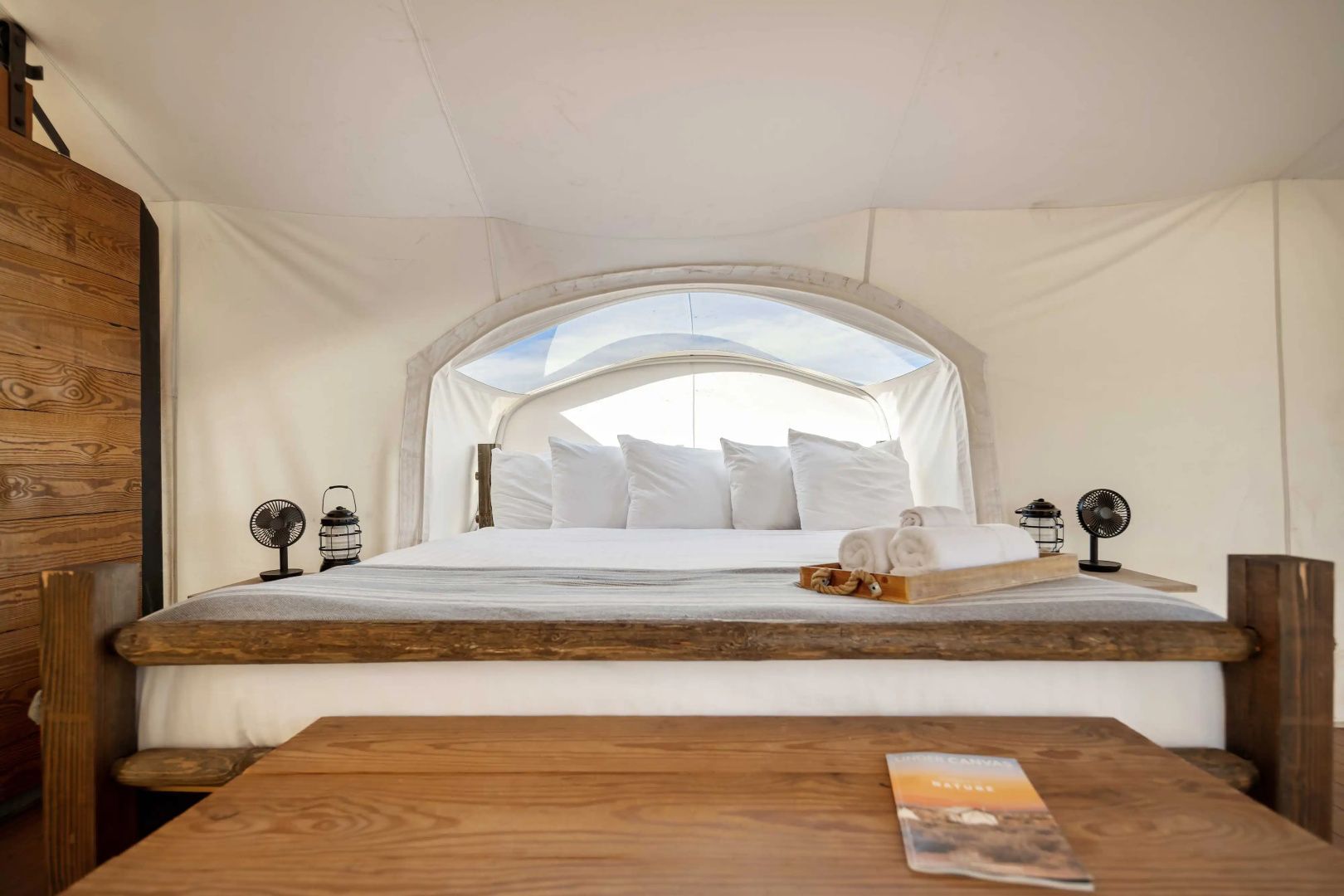 Doppelbett mit weißen Kissen und Sichtfenster unter der Zeltdecke.