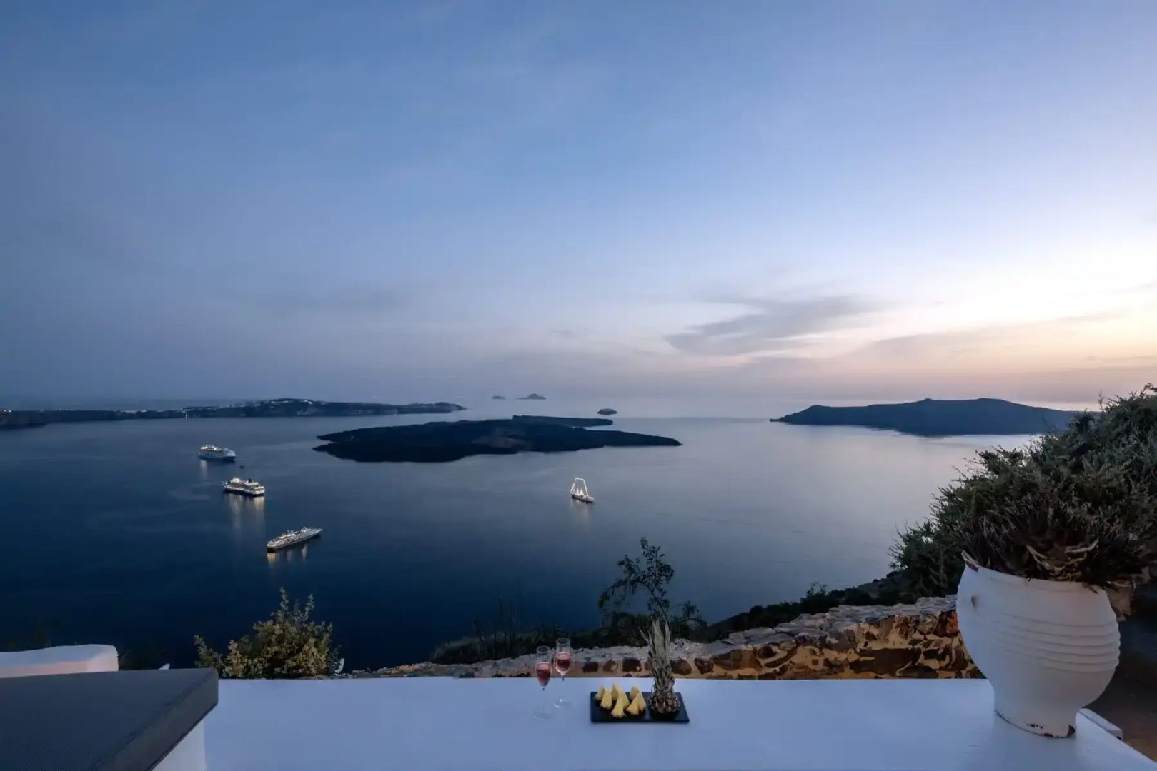 Abendlicher Blick von einer Mauer auf die Caldera und das ruhige Meer