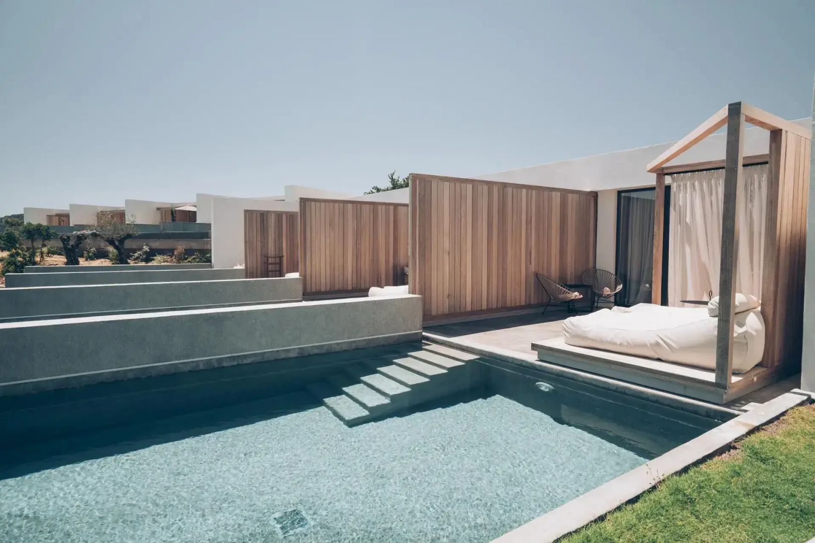 Reihe von privaten Swimmingpools an den Terrassen der Suiten mit Holztrennwänden als Sichtschutz.