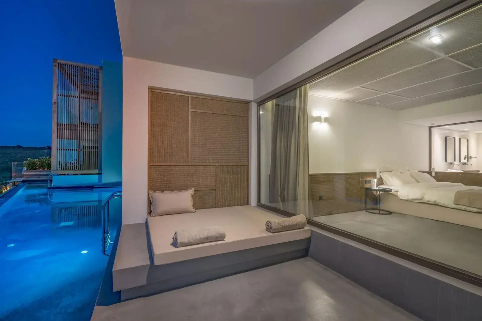 Überdachte Terrasse mit Tagesbett und gepolsterter Liege direkt am Pool.