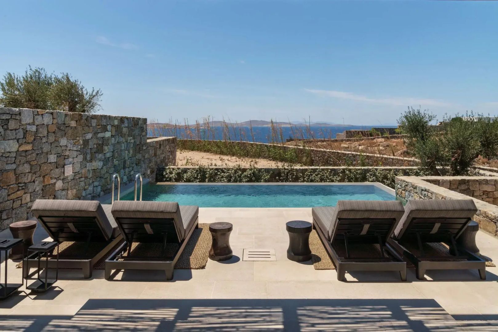 Beheizter Privatpool mit Liegen und Blick auf die Ägäis vor einer Suite im Kalesma Mykonos