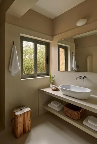 Badezimmer mit weißem Aufsatzwaschbecken, großem Spiegel und Tageslicht.