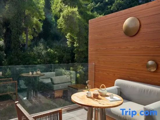 Terrasse mit Holzmöbeln, Teegeschirr und Blick auf grüne Hänge