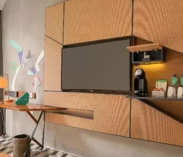 Wandkonsole mit Flachbildfernseher und einer Kaffeemaschine im Zimmer.