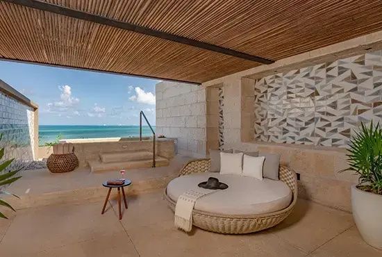 Überdachte Terrasse mit rundem Tagesbett und einem Jacuzzi mit Blick auf den Ozean