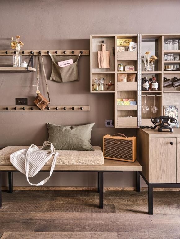 Sitzbank mit Garderobe, ein Wandregal mit Minibar und ein Retrotelefon auf dem Schrank.