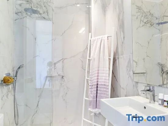 Modernes Badezimmer mit Waschbecken, Spiegelschrank und Dusche im Hintergrund.