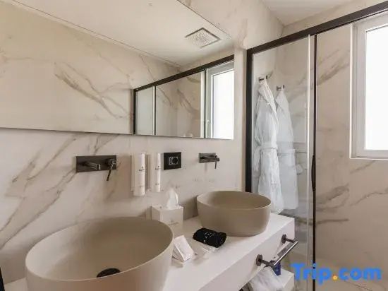 Doppelwaschtisch im Badezimmer mit zwei rundlichen Aufsatzbecken und großem Wandspiegel.