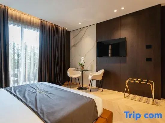 Sitzecke mit kleinem Tisch, zwei Stühlen und Wandfernseher im Schlafzimmer.