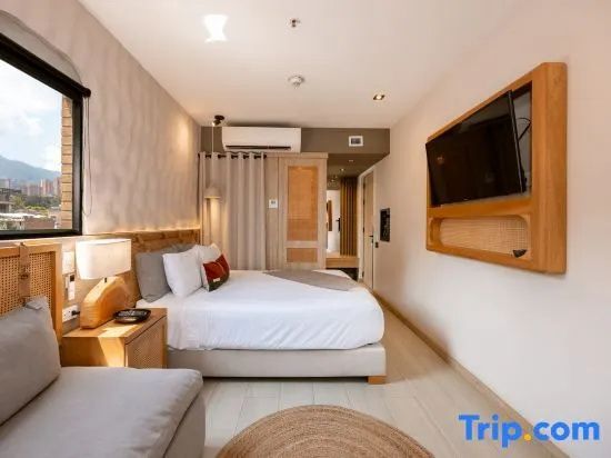 Helles Hotelzimmer mit großem Doppelbett, Wandfernseher und Holzelementen