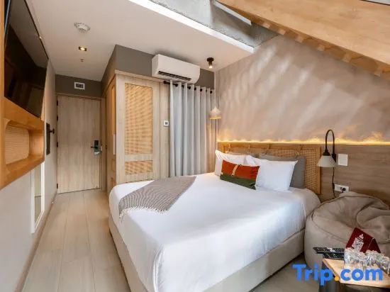 Schlafbereich mit Doppelbett, Holzschrank und Dachschräge mit Holzgebälk.