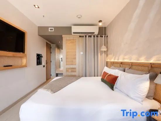 Blick in ein eingerichtetes Hotelzimmer mit Doppelbett und Fernseher an der Wand.