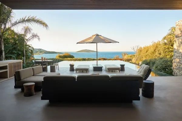 Terrasse mit Sofa und Blick auf den privaten Infinitypool sowie das Meer.