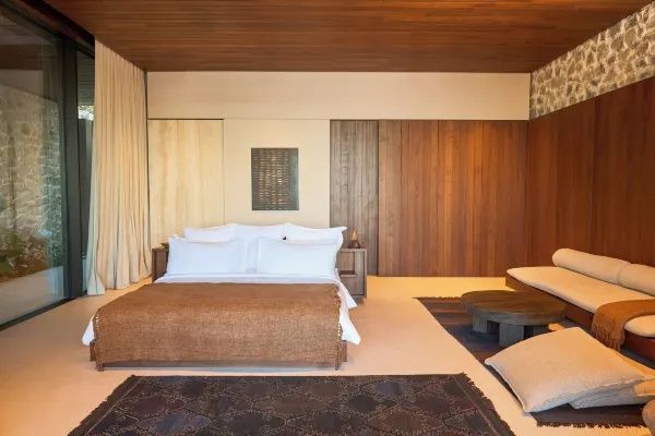 Geräumiges Schlafzimmer mit großem Bett, Holzwänden und Teppichen im modernen Stil.