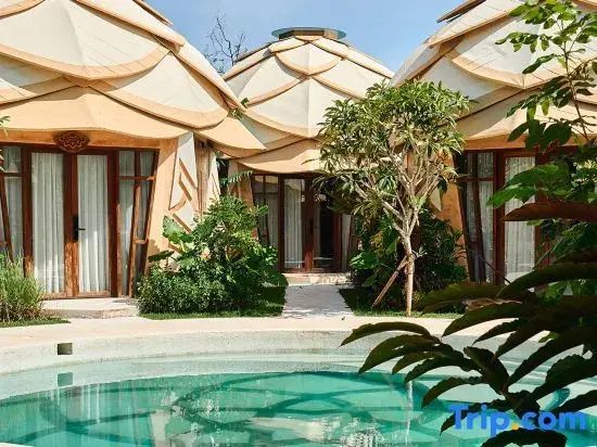 Kuppelförmige Bungalows mit hellem Dach rund um einen Außenpool.