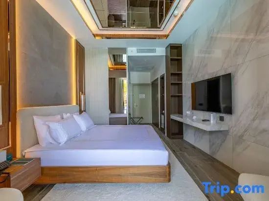 Modernes Schlafzimmer mit Holzdoppelbett, Wand-TV und indirekter Beleuchtung.
