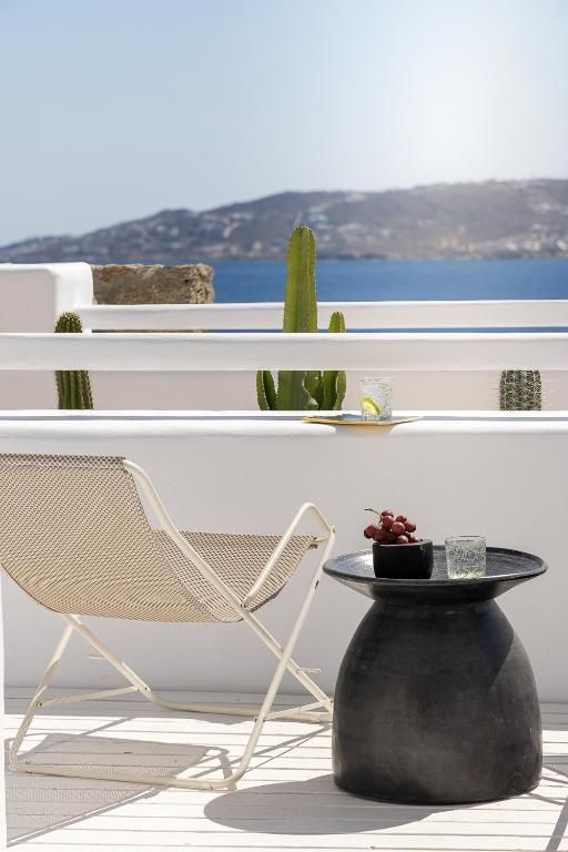 Sitzbereich auf der Terrasse mit klappbarem Stuhl und Meerblick im Hintergrund.