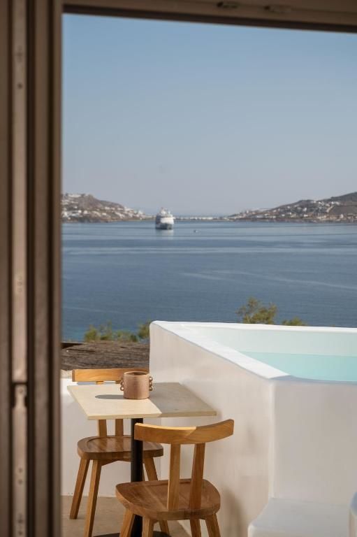 Ausblick von der Terrasse mit kleinem Pool auf eine Meeresbucht mit Schiff.
