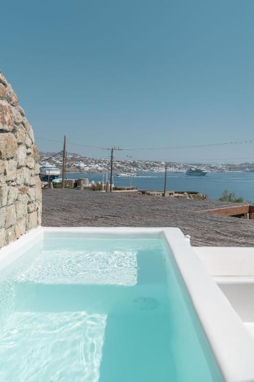 Kleiner Pool auf einer Terrasse mit freiem Blick auf das Meer und die Küste.