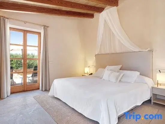 Schlafzimmer mit Doppelbett, feinem Stoffhimmel und Zugang zur Terrasse.