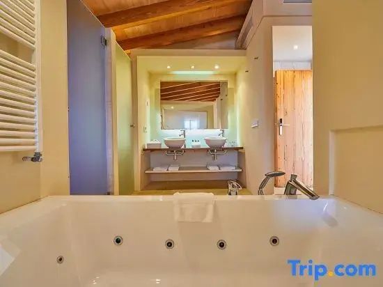 Badezimmer mit integrierter Whirlpool Wanne und Doppelwaschtisch.