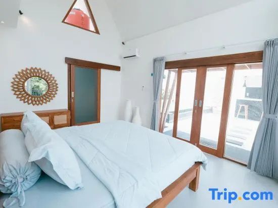 Schlafzimmer mit Blick auf ein Doppelbett und eine große Glastür zur Terrasse.