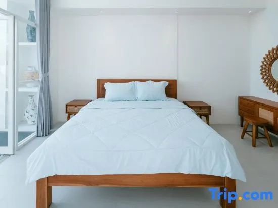 Zentraler Blick auf ein Holzdoppelbett mit hellblauer Bettwäsche und zwei Nachttischen.