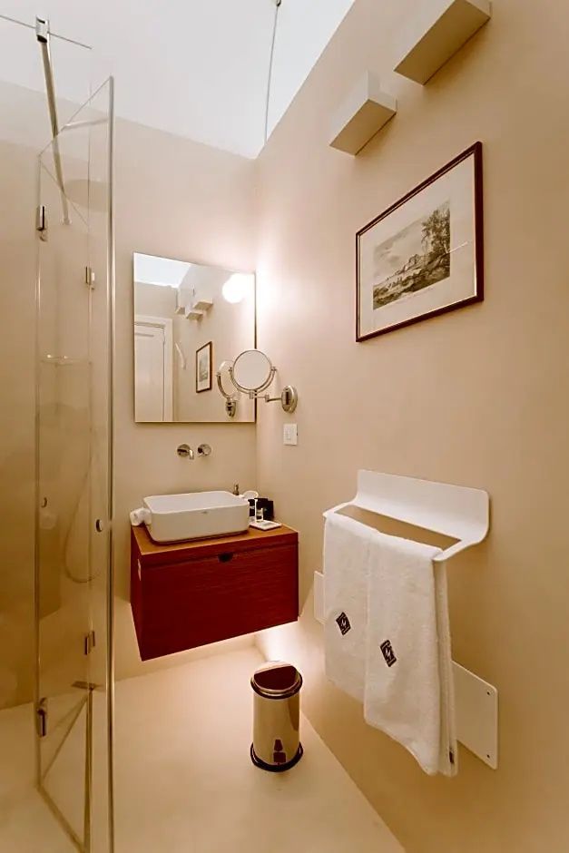 Badezimmer mit modernem Aufsatzwaschbecken, Spiegel und Duschkabine aus Glas.