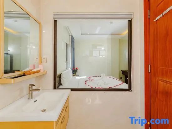 Waschbereich im Badezimmer mit Fensterscheibe zum angrenzenden Schlafbereich.