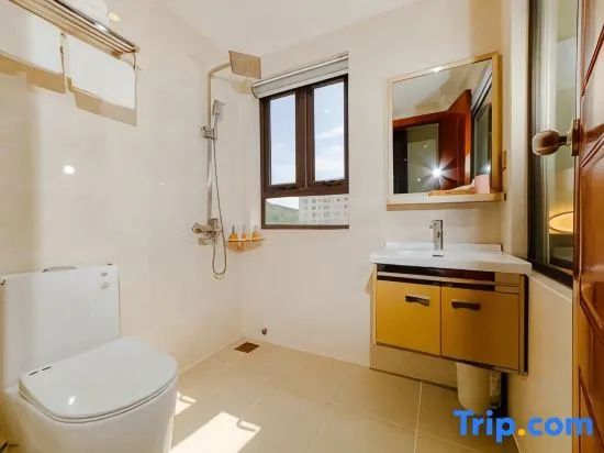 Helles Badezimmer mit Dusche, WC, Waschbecken, Unterschrank und Wandspiegel.